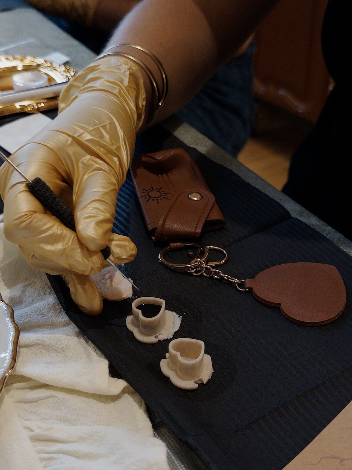 Détail de l'atelier : matériel de tatouage et objet en simili-cuir en cours de personnalisation